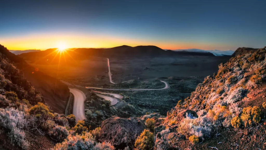 Route sinueuse dans le paysage volcanique de La Réunion au lever du soleil